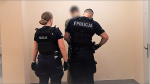 Policjanci zakładają kajdanki zatrzymanemu.