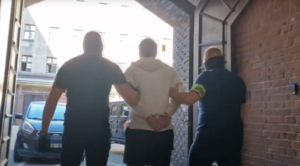 zatrzymany jest prowadzony przez policjantów.