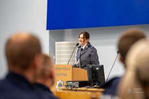 Umundurowana policjantka przy mównicy.