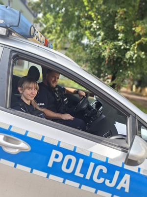 policjantka i policjant siedzą w radiowozie.