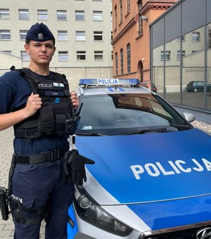 Policjant przy radiowozie.