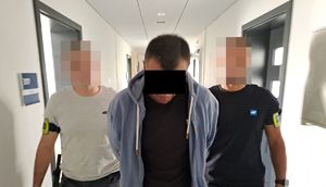 Dwaj policjanci prowadza zatrzymanego.