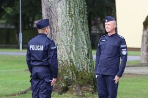 Policjant składa policjantowi meldunek.