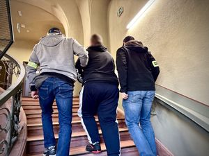 policjanci prowadzą zatrzymanego.