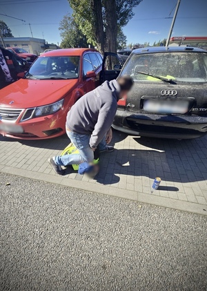 Policjant z leżącym na ziemi zatrzymanym.
