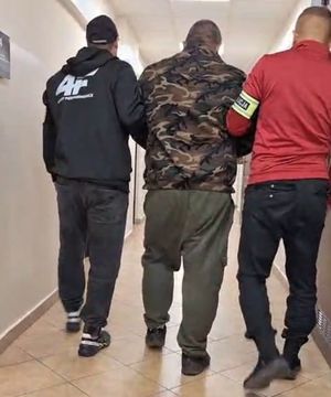 Policjanci prowadzą zatrzymanego.