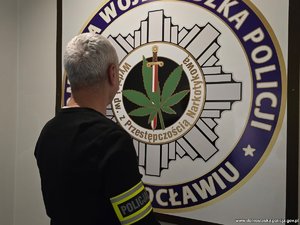 Policjant operacyjny z opaską na ramieniu z napisem policja.
