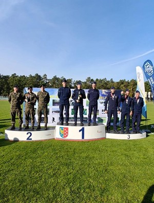 Zawodnicy w mundurach na podium.