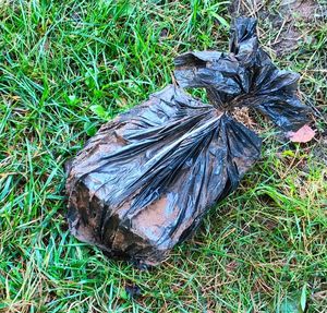 Na trawie leży prostokątny przedmiot owinięty w czarny worek.