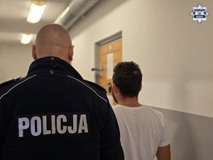 Zatrzymany stoi tyłem z policjantem.