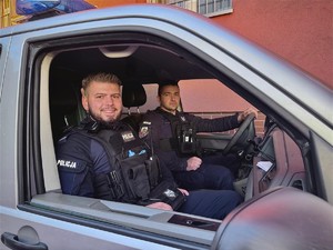 policjanci siedzą w radiowozie.