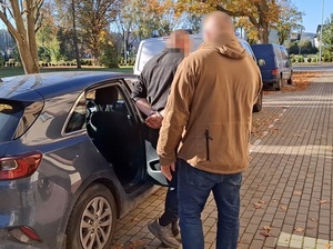 zatrzymany idzie z policjantami.