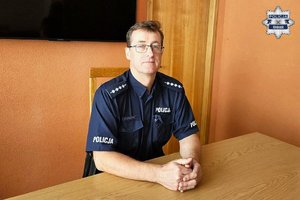 policjant siedzi za biurkiem.