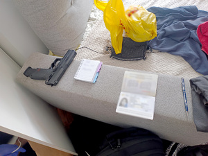 Pistolet i dokumenty znalezione w lokalu.