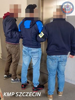 Dwaj policjanci prowadzą zatrzymanego.