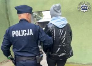 Policjant prowadzi zatrzymaną.