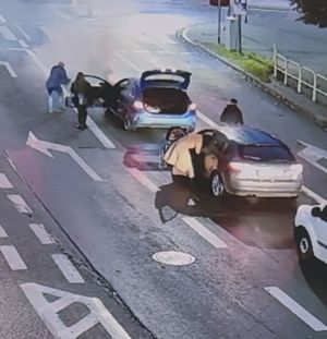 Gaszenie płonącego auta na jezdni.