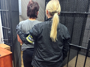 Zatrzymana prowadzona przez policjantkę.