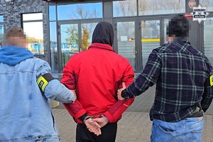 Zdjęcie przedstawia policjantów kryminalnych prowadzących zatrzymanego sprawcę wypadku do rudzkiego sądu.