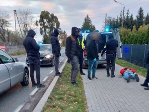 Policjanci ubrani po cywilnemu z zatrzymanymi osobami.
