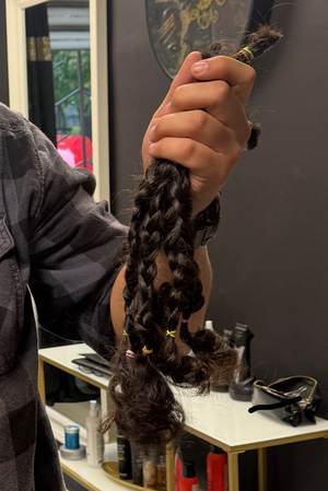 Ścięte przez policjanta włosy trzymane w dłoni.