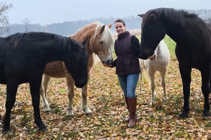Policjantka stoi obok koni.