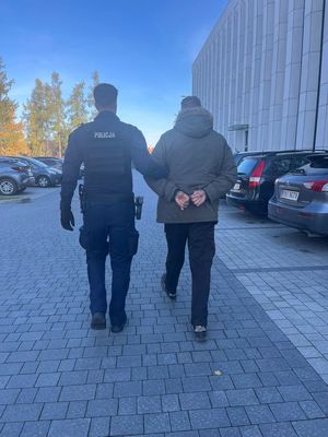 Zatrzymany prowadzony przez policjanta.