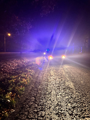 Radiowóz stoi na drodze na światłach. Pora nocna.