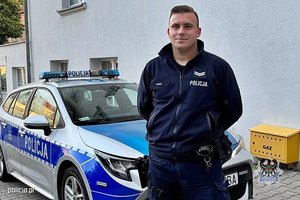 policjant na tle radiowozu