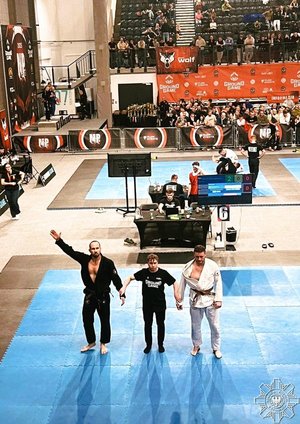 Dwaj zawodnicy na macie i sędzia.