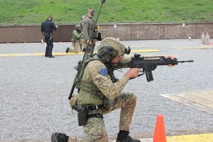 Funkcjonariusz celuje z karabinu podczas zawodów strzeleckich.