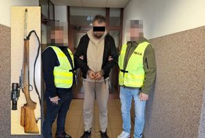 Dwaj policjanci prowadza zatrzymanego.