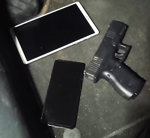 Tablet, smartfon i pistolet na blacie.