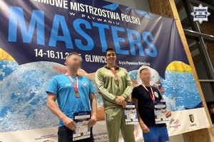 Zdjęcie przedstawia trzech mężczyzn na podium.