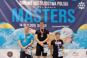 Zdjęcie przedstawia trzech mężczyzn na podium.
