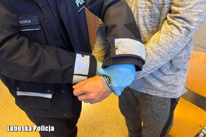 Policjantka zakłada kajdanki mężczyźnie.