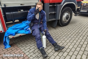 Policjant pobierający tlen z maseczki.
