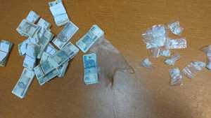 Zabezpieczone narkotyki w woreczkach i zabezpieczone banknoty pieniędzy.