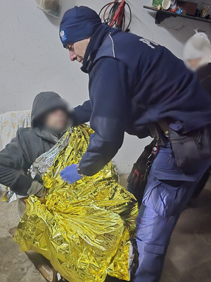 policjant okrywa kocem mężczyznę.