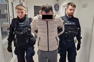 Policjanci prowadzą zatrzymanego.