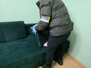 Policjant demontuje kanapę.