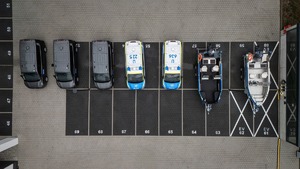 Pięć policyjnych furgonów i dwie łodzie - widok z lotu ptaka.