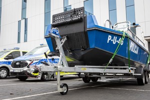 Łódź policyjna i dwa furgony.