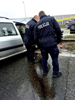 trasa szybkiego ruchu. miejsce zdarzenia. policjanci stoją obok ugaszonego pojazdu.