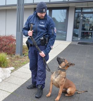 Funkcjonariusz z psem na smyczy.