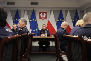 Uczestnicy spotkania siedzą przy owalnym stole.