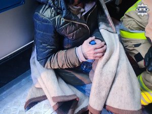 odnaleziona zaginiona kobieta siedzi przykryta.