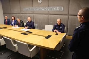 Komendant Główny Policji i Prokurator Krajowy i inni policjanci siedzą przy stole.