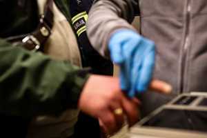 Policjant pobiera od zatrzymanego odciski palców.