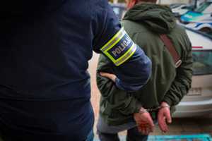 Policjant prowadzi zatrzymanego.